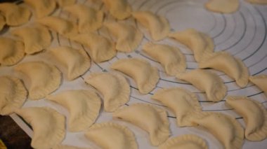 Vareniki, hamur köftesi ya da patates ya da peynirli pirogy, yuvarlak ölçekli beyaz silikon bace meyveler - geleneksel Ukrayna yemeği. Patatesli çiğ hamur köftesi pişirmek. Ravioli.
