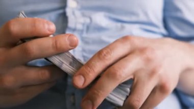 Bir tomar Amerikan doları bir elde toplanır. Amerikan doları rulosu. İnsan eli. İş ve finans. Para ve finans. Nakit iş