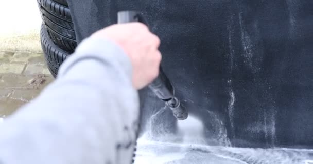 寒い日にセルフサービスで高圧水車のカーペットを洗う男 現代の車のインテリアについての詳細 車のカーペットのクリーニングソリューションを使用してきれいにする — ストック動画