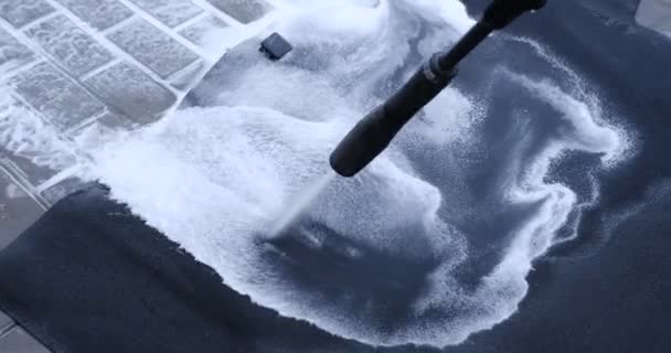 寒い日にセルフサービスで高圧水車のカーペットを洗う男 現代の車のインテリアについての詳細 車のカーペットのクリーニングソリューションを使用してきれいにする — ストック動画