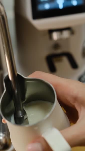 バリスタミルク蒸し バリスタはラテを用意する コーヒーを飲んで 接近中だ バリスタはコーヒーマシンの熱い蒸気でピッチャーでミルクを飲みます 牛乳の泡を作る過程は — ストック動画