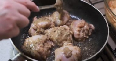 Ev yapımı Kore baharatlı chiken tabağı, ayçiçeği yağıyla tavada kızartılıyor. Baharatlı sos ekleniyor.