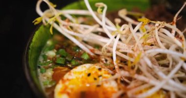 Lezzetli bir kase ramen, yeşillik, yosun, erişte, yumurta ve et. Yakın çekim zengin, besleyici çorbayı yakalar, yemek tutkunları için mükemmel bir aşçılık ilham kaynağıdır.