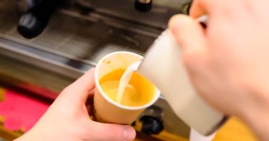 Barista muzlu sütü tek kullanımlık kapuçinoya doldurur. Kahveyle karıştırılan sütün pürüzsüz akışını yakalar ve modern bir kahve sanatını ön plana çıkaran zengin bir doku yaratır..