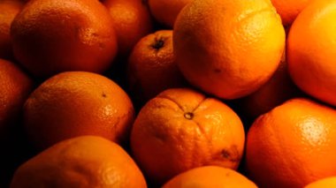 Tezgahta güzel aydınlatılmış taze portakallar, sağlıklı beslenme konsepti olan canlı narenciye meyvelerine yakın çekim. Yemek fotoğrafçılığı, yaz meyvesi, organik, vitamin c zengin, parlak turunçgil tazeliği için mükemmel..