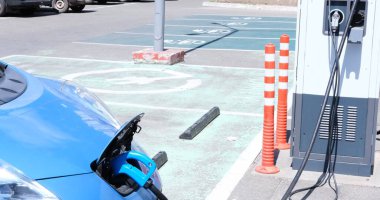 Şarj istasyonuna park etmiş bir elektrikli araç, hızlı şarj alıyor. Çevre dostu ulaşım kavramları ve sürdürülebilir enerji çözümleri için ideal