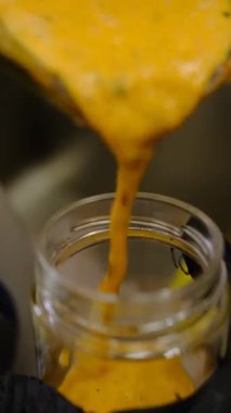 Deniz karabatağı püresi karıştırıcı kavanozdan cam bir kavanoza dökülür. Depolama için pürüzsüz doku canlı renk taze doğal tatlar çay tatlısı veya yemek tarifleri için ideal zanaatsal hazırlık.