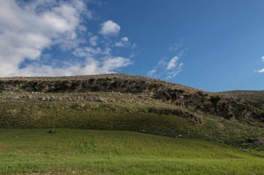 Mountain landscape with green grass, blue sky and white clouds. Bazina Joumine, Bizerte, Tunisia