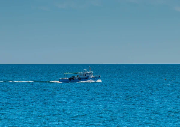 一艘小船在突尼斯Mahdia的蓝色海滩上航行 — 图库照片
