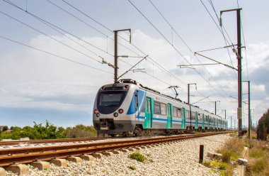 Güneşli bir günde hareket halindeki yerel tren: Demiryolu Seyahatinin Güzelliğini Deneyin