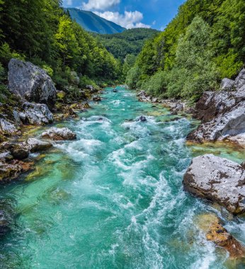 Soca Vadisi, Slovenya - Zümrüt Alp Nehri 'nin yeşil yapraklı güneşli bir yaz gününde nehirden geçen rafting botlarıyla Soca nehrinin havadan panoramik manzarası. Slovenya 'da rafting