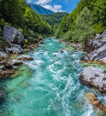 Soca Valley, Slovenia - Aerial panoramic view of the emerald alpine river Soca with rafting boats going down the river on a bright sunny summer day with green foliage. Whitewater rafting in Slovenia clipart