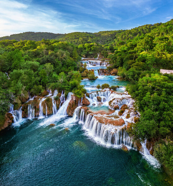 Krka, Croatia - Aerial view of the beautiful Krka Waterfalls in Krka National Park on a bright summer morning with green foliage, turquoise water and blue sky