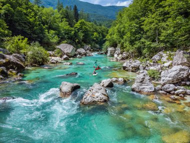 Soca Vadisi, Slovenya - Parlak güneşli bir yaz gününde yeşil yapraklarla nehirden geçen rafting botlarıyla zümrüt Alp Nehri 'nin havadan görünüşü. Slovenya 'da rafting