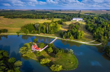 Deg, Macaristan - Deg köyündeki güzel Hollanda evinin (Hollandi haz) havadan panoramik manzarası arka planda bir yaz sabahı mavi gökyüzü ile birlikte Festetik Sarayı olan küçük bir ada