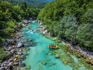 Soca Vadisi, Slovenya - Parlak güneşli bir yaz gününde yeşil yapraklarla nehirden geçen rafting botlarıyla zümrüt Alp Nehri 'nin havadan görünüşü. Slovenya 'da rafting