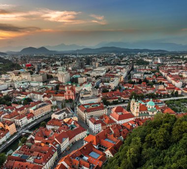 Ljubljana, Slovenya - Fransisken Annunciation Kilisesi, Ljubljana Katedrali, Slovenya 'nın ufuk çizgisi ve renkli günbatımı ile Ljubljana' nın havadan panoramik manzarası
