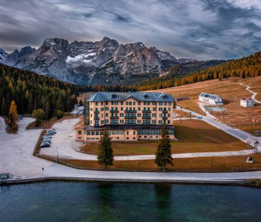 Misurina, İtalya - Güney Tyrol 'daki Misurina Gölü' ndeki İtalyan Dolomitlerinin sabah güneşleri, bulutlu gökyüzü ve rehabilitasyon merkezi ile Cristallo dağlarının havadan görünüşü