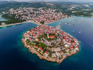Primosten, Croatia - Aerial view of Primosten peninsula and old town on a sunny summer day in Dalmatia, Croatia with red rooftops and turquoise blue sea water at the Adriatic sea coast clipart