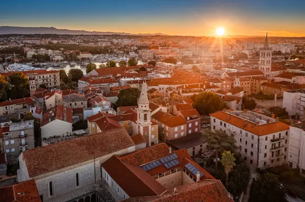 Zadar, Hırvatistan - Kızıl çatıları olan eski Zadar kasabası, St. Donatus Kilisesi ve St. Anastasia Katedrali 'nin çan kulesi yaz sabahında gün doğumunda doğan altın güneşle birlikte