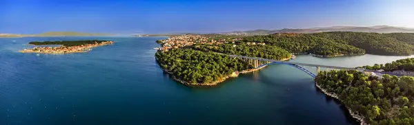 stock image Krapanj, Croatia - Aerial panoramic view of Morinje bridge (Morinjski most) on a sunny summer morning with island of Krapanj and Brodarica town at background with clear blue sky