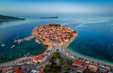 Primosten, Hırvatistan - Hırvatistan 'ın başkenti Dalmaçya' da Primosten yarımadasının havadan panoramik manzarası, St. George Kilisesi, güneşli bir yaz sabahı eski bir kasaba. Mavi gökyüzü, yat marinası ve turkuaz deniz suyu gün doğumunda.