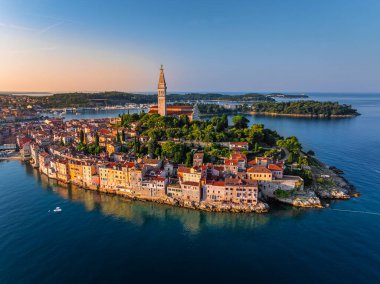 Rovinj, Hırvatistan - Hırvatistan 'ın Istria kentinde bir yaz sabahı gün doğumunda St. Euphemia Kilisesi ile eski Rovinj kasabasının havadan görünüşü. Adriyatik Denizi kıyısında altın gökyüzü ve kırmızı çatılar