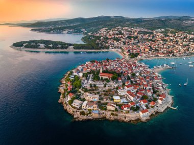 Primosten, Hırvatistan - Hırvatistan 'ın başkenti Dalmaçya' da güneşli bir yaz gününde Primosten yarımadası ve eski kentin havadan görünüşü, kırmızı çatıları ve Adriyatik deniz kıyısında mavi deniz suyuyla turkuaz