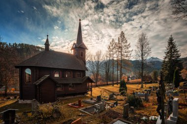 Tatranska Javorina, Slovakya - Tatranska Javorina köyünün yakınlarındaki sevimli ahşap Roma Katolik Kilisesi, güneşli bir sonbahar günü, arka planda yüksek Tatras dağlarının karlı zirveleri ile