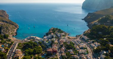 Mallorca, İspanya - Cala Clara ve Cala Molins, plaj, oteller, yatlar ve arka planda dağlarla birlikte Mallorca adasındaki Cala Sant Vicenc panoramik hava manzarası