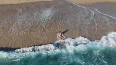 Genç bir kız dalgalarla mutlu bir şekilde savaşıyor.