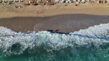 Genç bir kız dalgalarla mutlu bir şekilde savaşıyor.