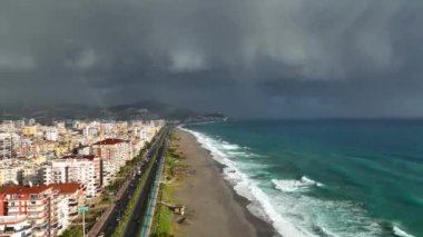 Bir adam kumsal mavisi deniz dokusunda koşar.