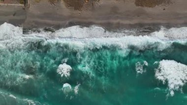 Bir adam kumsal mavisi deniz dokusunda koşar.