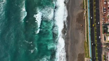 Bir adam kumsal mavisi deniz dokusunda koşar.