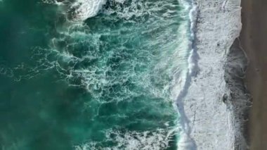 Bir adam kumsal mavisi deniz dokusunda koşar.