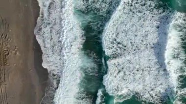 Bir adam kumsal mavisi deniz dokusunda koşar.