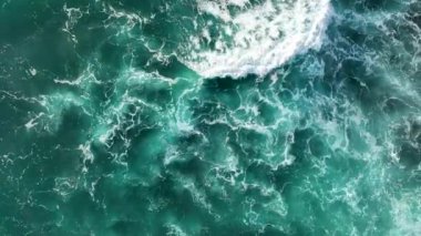 Bir adam kumsal mavisi deniz dokusunda koşar.