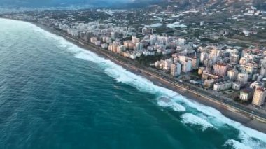 Bir adam kumsal mavisi deniz dokusunda koşar.