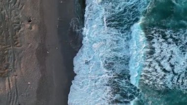 Bir adam kumsal mavisi deniz dokusunda koşar.