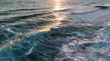 Bir adam kumsal mavisi deniz dokusunda koşar.