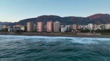 Bir adam kumsal mavisi deniz dokusunda koşar.