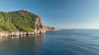 Mavi deniz ve liman kenti arka planıyla Alanya plajı dağ manzaralı.