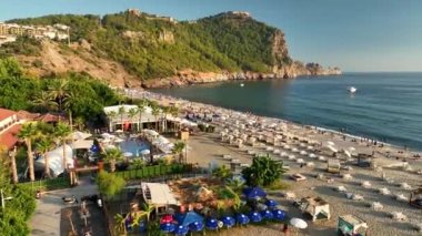 Mavi deniz ve liman kenti arka planıyla Alanya plajı dağ manzaralı.