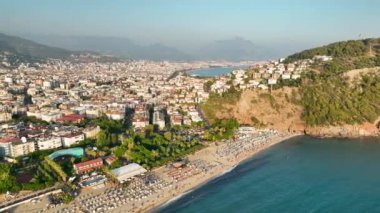 Mavi deniz ve liman kenti arka planıyla Alanya plajı dağ manzaralı.