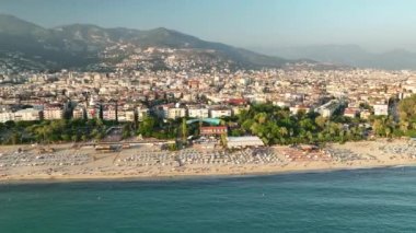 Mavi deniz ve liman kenti arka planıyla Alanya plajı dağ manzaralı.