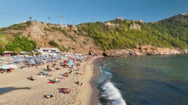 Mavi deniz ve liman kenti arka planıyla Alanya plajı dağ manzaralı.