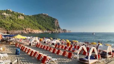 Mavi deniz ve liman kenti arka planıyla Alanya plajı dağ manzaralı.