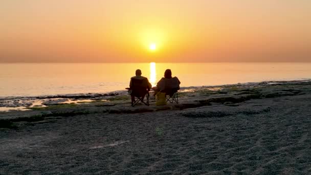 人们坐在海滩上观看日落 — 图库视频影像