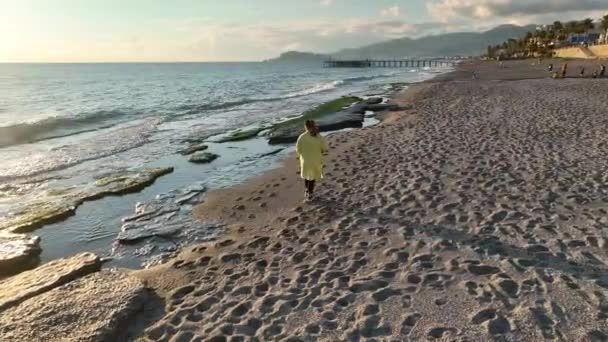 Dziewczyna Żółtym Płaszczu Spaceruje Plaży — Wideo stockowe